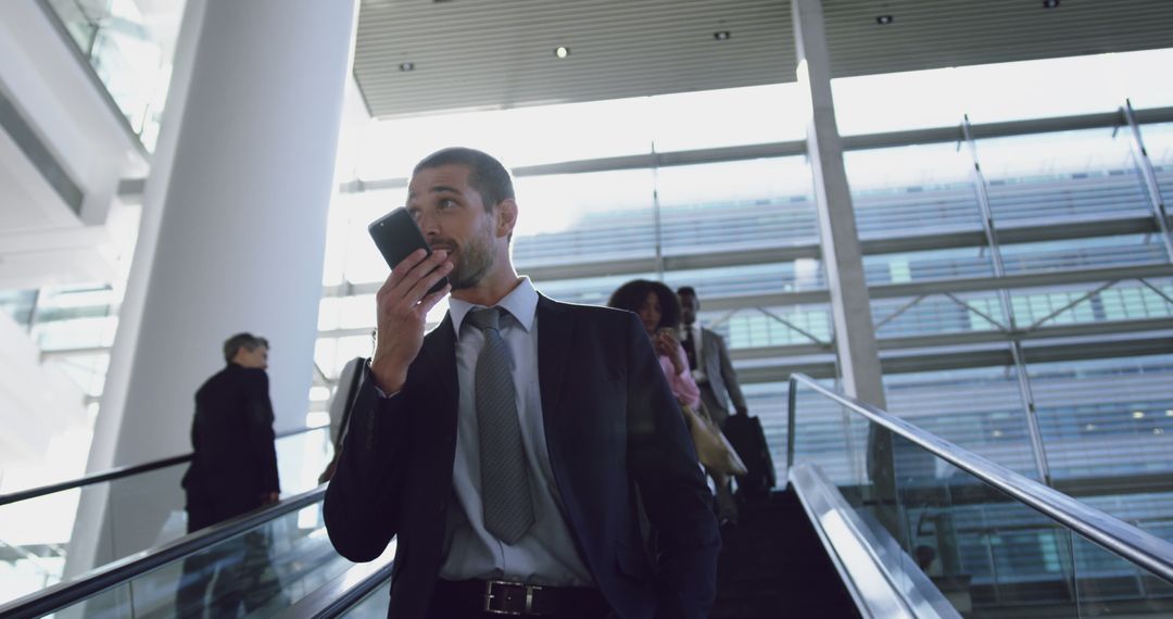 Businessman Using Voice Assistant on Smartphone While on Escalator - Free Images, Stock Photos and Pictures on Pikwizard.com