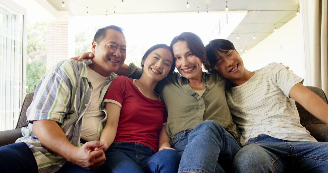 Diverse Family Smiling on Couch Celebrating Togetherness
