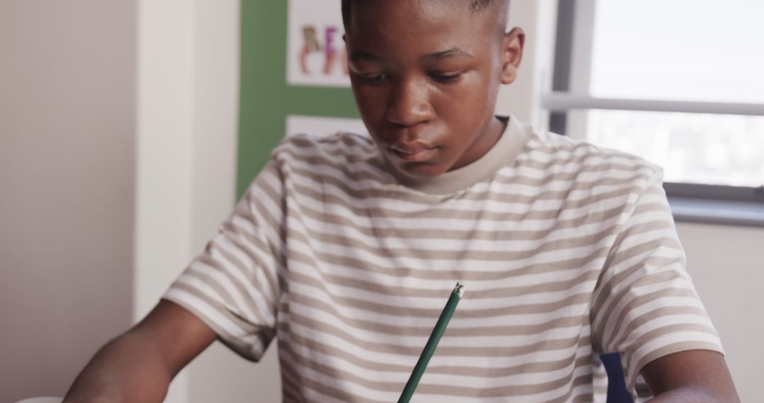 Focused African American Student Writing at Classroom Desk
