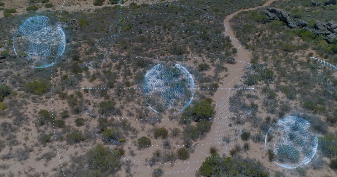 Aerial desert mapping with holographic geospatial orbs hovering over winding dirt trail