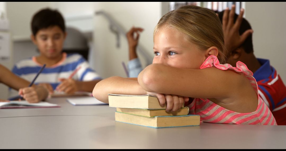 Thoughtful Girl Sitting in Classroom with Books During Lesson - Free Images, Stock Photos and Pictures on Pikwizard.com