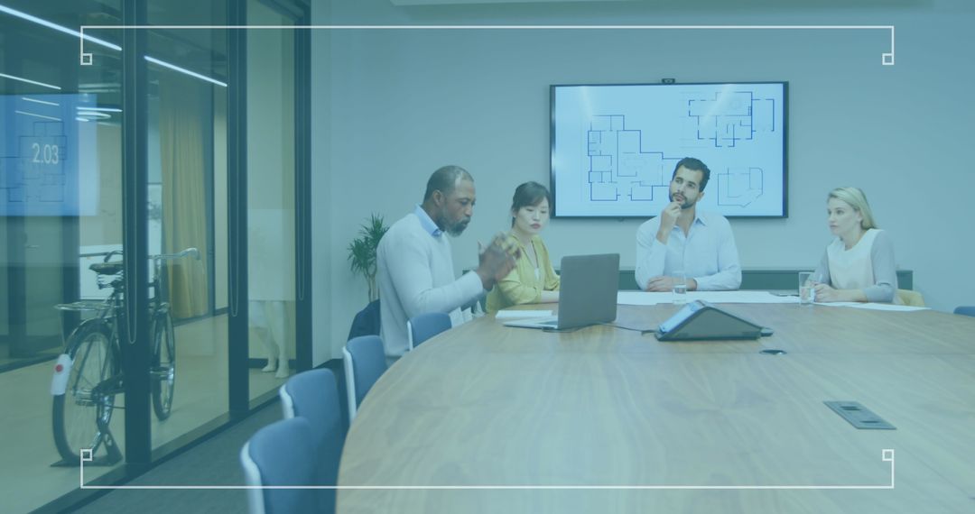 Diverse Team Meeting Analyzing Business Data in Modern Office