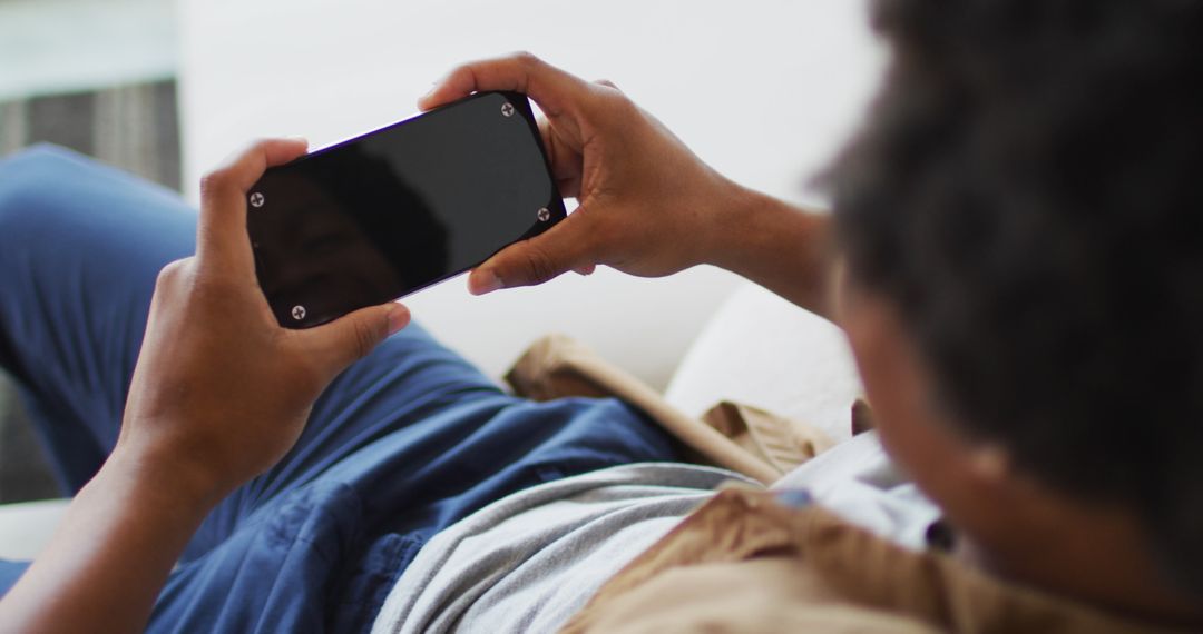 Man Relaxing Using Smartphone at Home Closeup