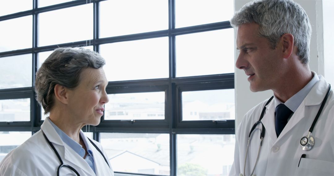 Two Doctors Discussing in Hospital Corridor - Free Images, Stock Photos and Pictures on Pikwizard.com