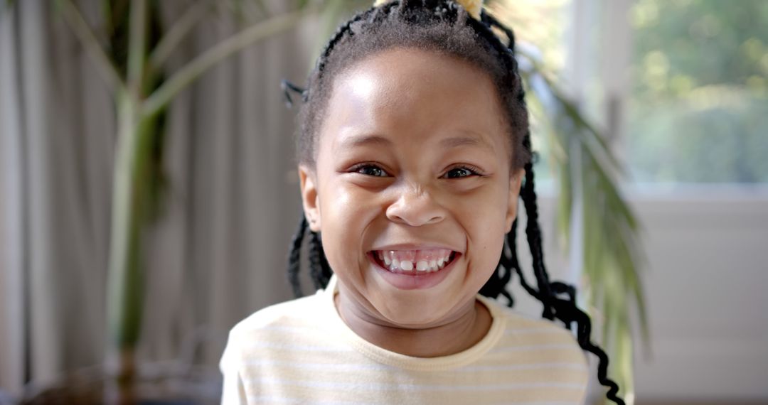 Joyful African American Girl Smiling by Window - Free Images, Stock Photos and Pictures on Pikwizard.com