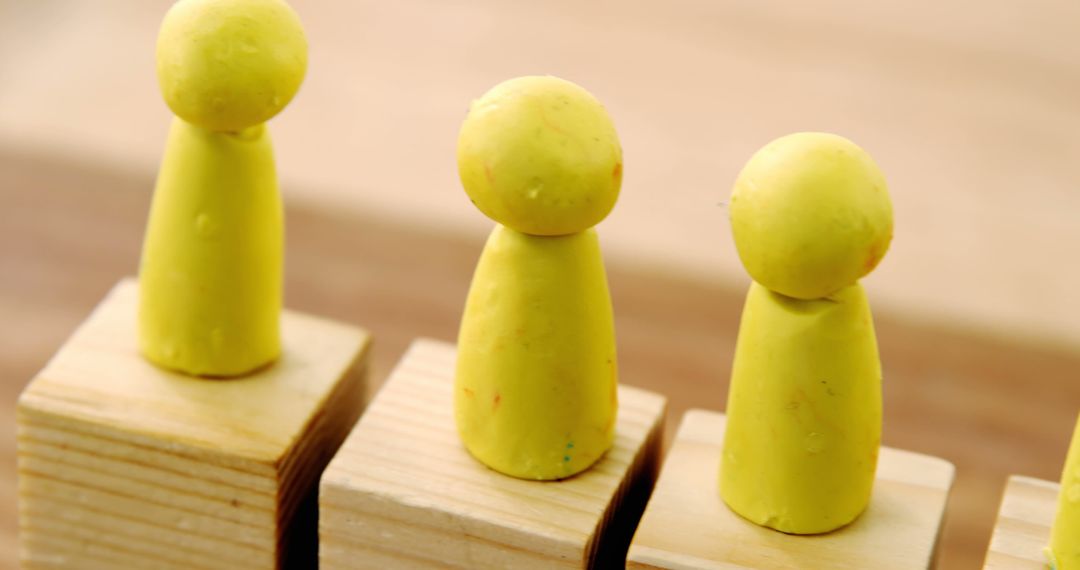 Yellow Clay Figures on Wooden Blocks - Free Images, Stock Photos and Pictures on Pikwizard.com