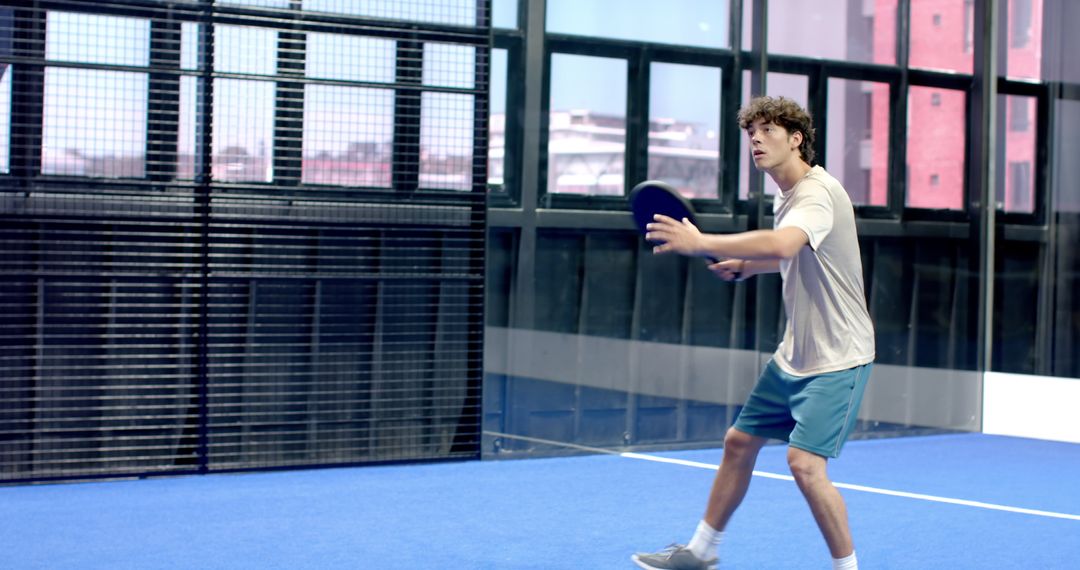 Energetic Man Preparing for Overhead Shot in Padel Match