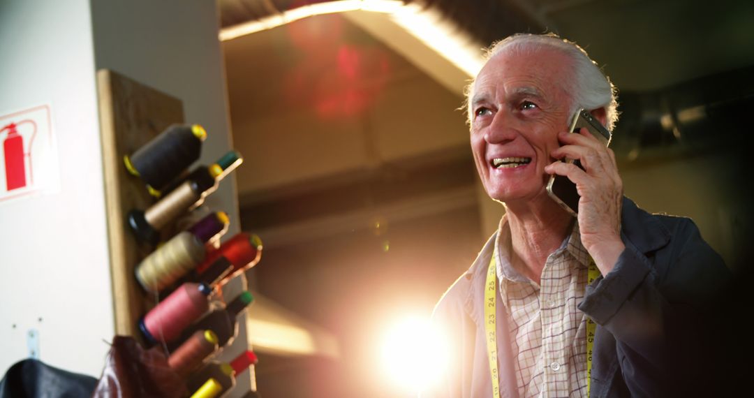 Senior Shoemaker Talking on Mobile in Artisan Workshop