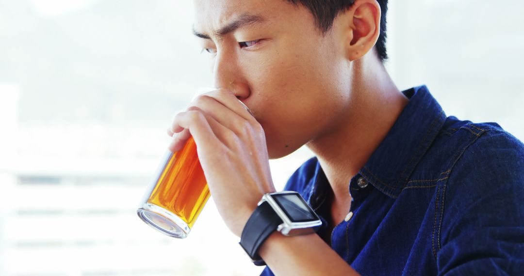 Young Man Drinking Tea and Wearing Smartwatch - Free Images, Stock Photos and Pictures on Pikwizard.com