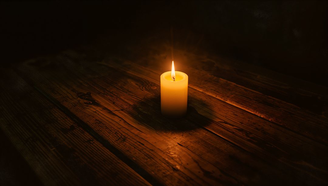 Warm Glow of Lit Candle Illuminates Rustic Wooden Table
