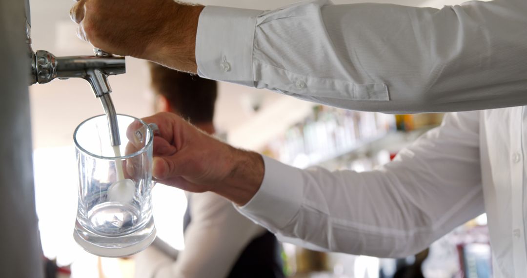 Barman Serving Fresh Beer from Tap at Bar Counter