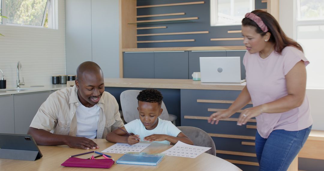 Father Assisting Son with Homework at Kitchen Table in Modern Home