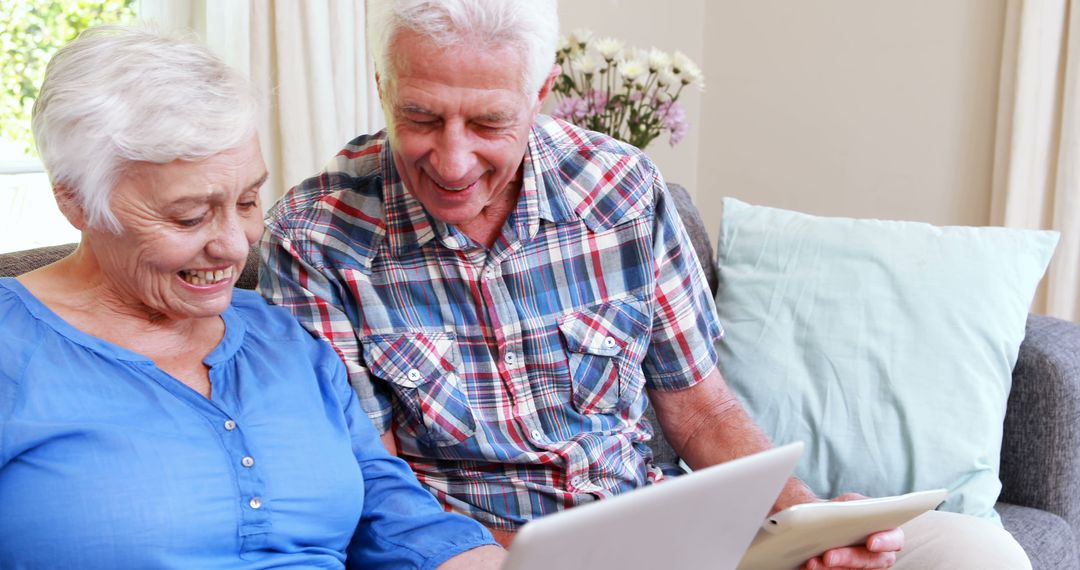 Senior Couple Using Digital Tablets on Sofa at Home - Free Images, Stock Photos and Pictures on Pikwizard.com