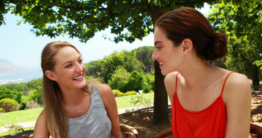 Two Young Women Enjoying Outdoor Chat in Park - Free Images, Stock Photos and Pictures on Pikwizard.com