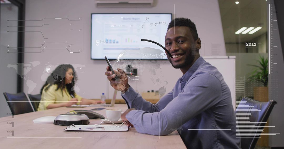 Smiling businessman holding phone at meeting table showcasing collaboration and technology