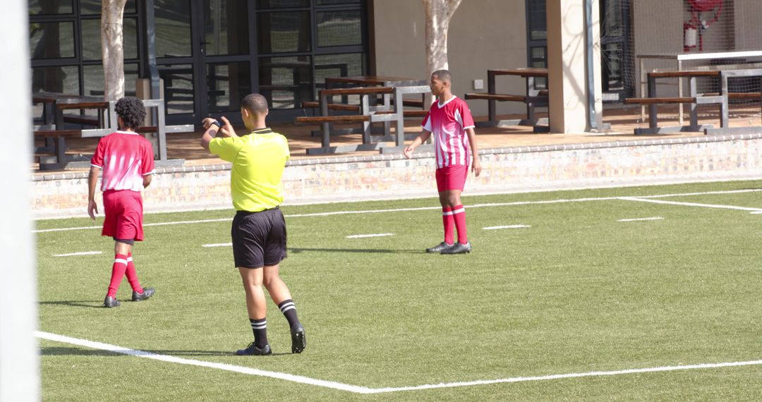 Referee and Players on Soccer Field During Competitive Match