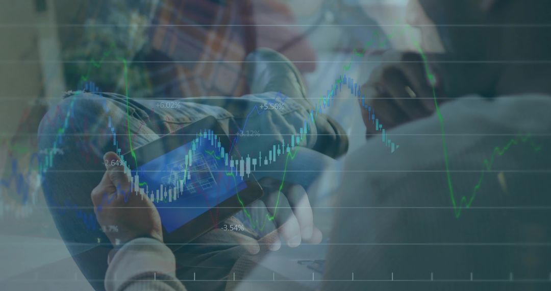Man holding tablet studying candlestick market charts while collaborating on laptop