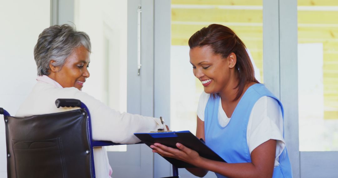 Nurse Assisting Elderly Woman in Wheelchair with Paperwork - Free Images, Stock Photos and Pictures on Pikwizard.com