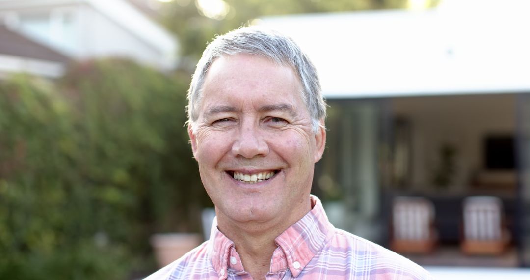 Smiling Senior Man Relaxed in Rustic Backyard Setting