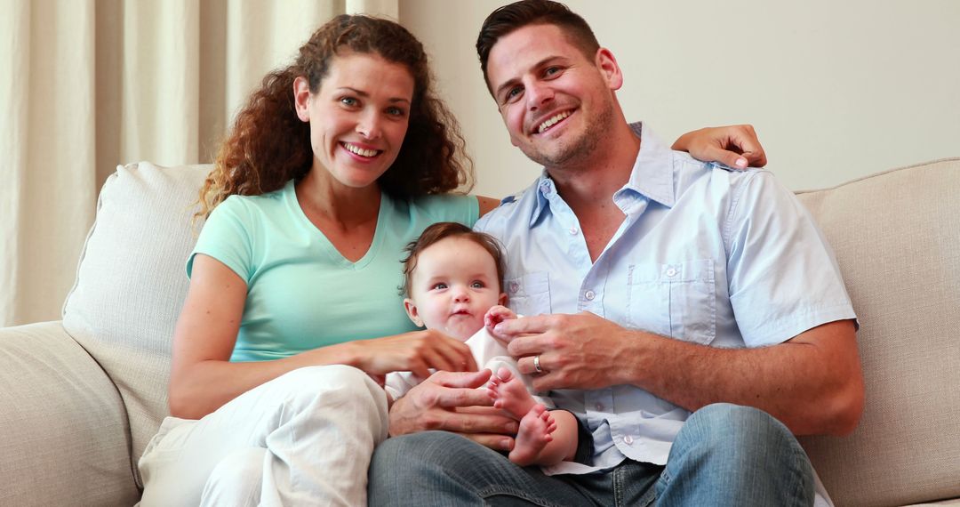 Happy Parents with Baby Relaxing on Sofa - Free Images, Stock Photos and Pictures on Pikwizard.com