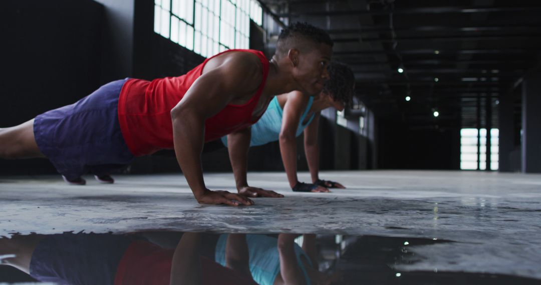 Two Athletic Individuals Performing Push-Ups in Industrial Space - Free Images, Stock Photos and Pictures on Pikwizard.com