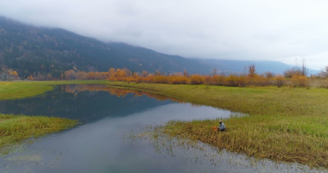 Solitary Man Fishing by Mountainous Lake in Autumn - Free Images, Stock Photos and Pictures on Pikwizard.com