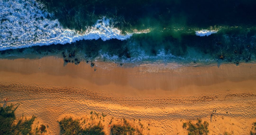 Aerial View of Waves Crashing on Sandy Beach at Sunset - Free Images, Stock Photos and Pictures on Pikwizard.com