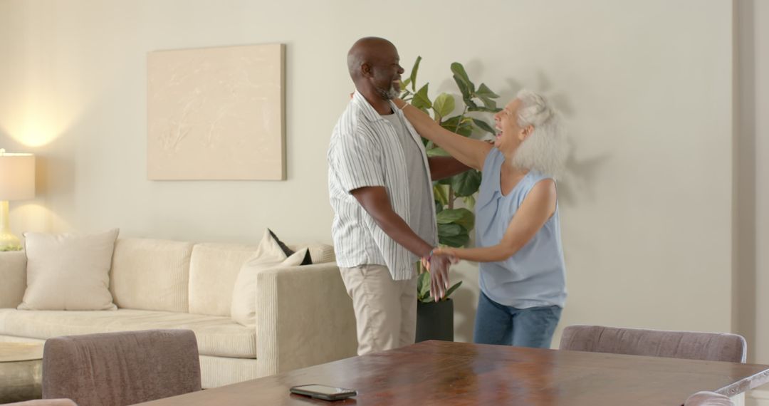 Joyful Senior Couple Dancing at Home in Comfortable Living Space