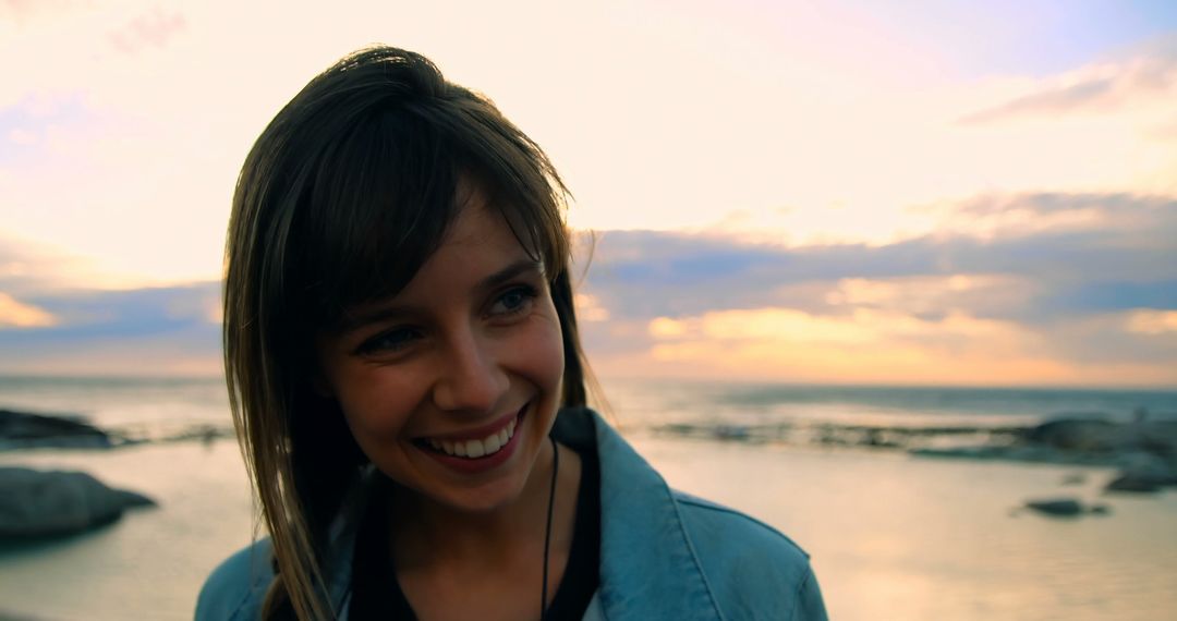 Young Woman Smiling at Sunset on Beach - Free Images, Stock Photos and Pictures on Pikwizard.com