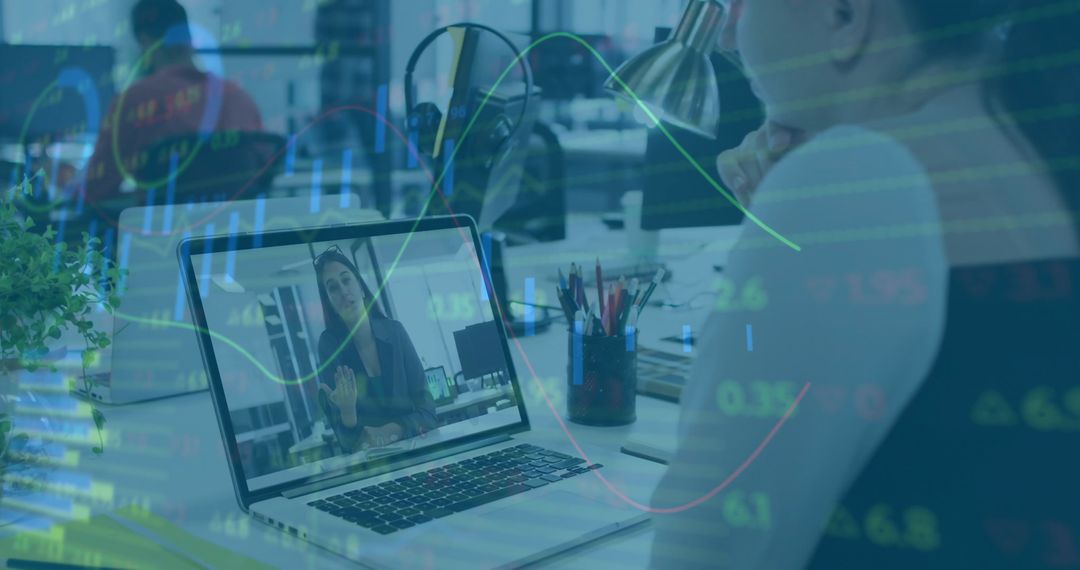 Remote team video meeting with laptop and financial data overlay in modern office