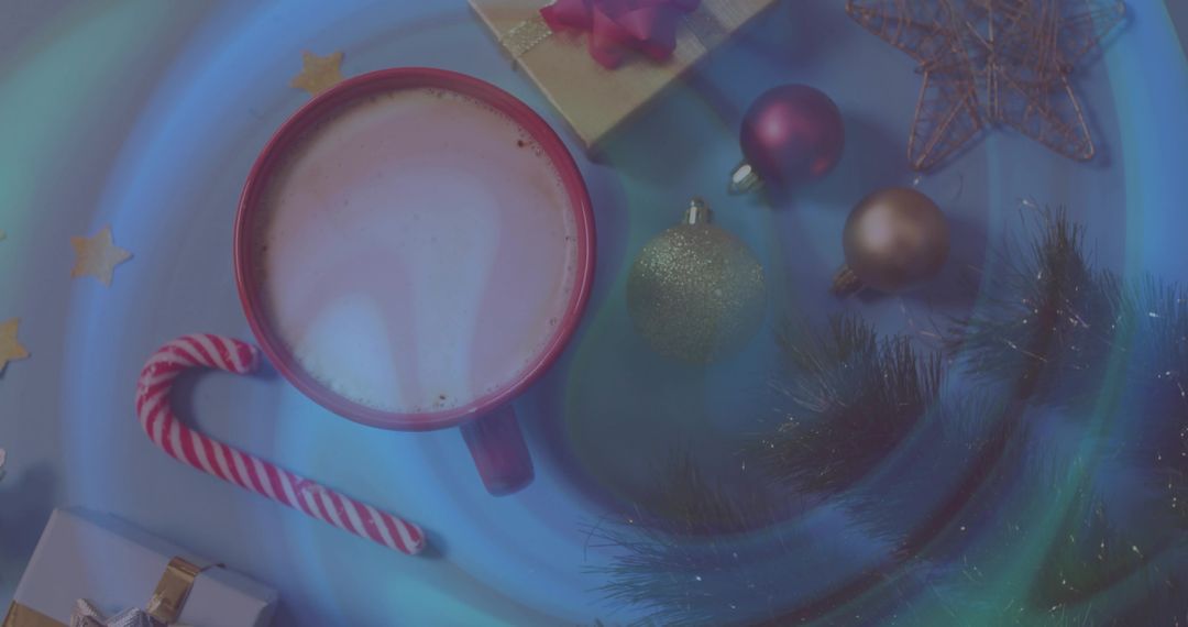 Cozy cocoa mug with candy cane and glitter ornaments on glowing blue holiday tabletop