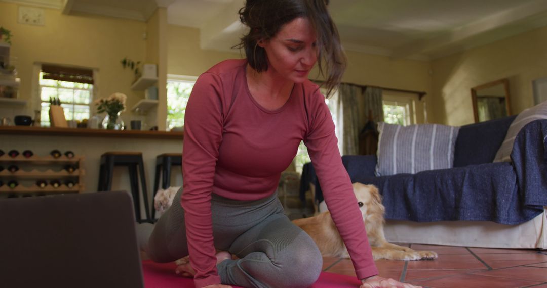 Caucasian woman exercising with her pet dog using laptop at home - Free Images, Stock Photos and Pictures on Pikwizard.com