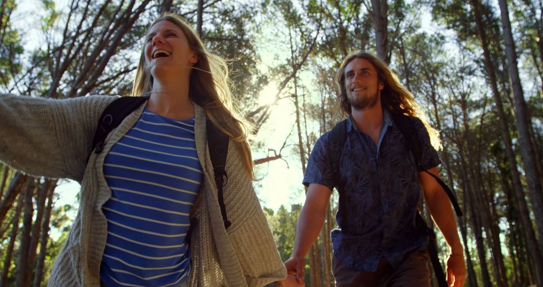 Couple Exploring Forest in Daylight, Holding Hands and Smiling