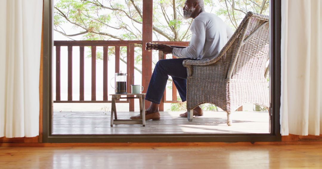 Man Relaxing on Porch with Guitar and Coffee - Free Images, Stock Photos and Pictures on Pikwizard.com