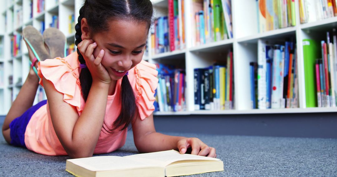 Young Girl Reading Book on Library Floor Smiling Happily - Free Images, Stock Photos and Pictures on Pikwizard.com