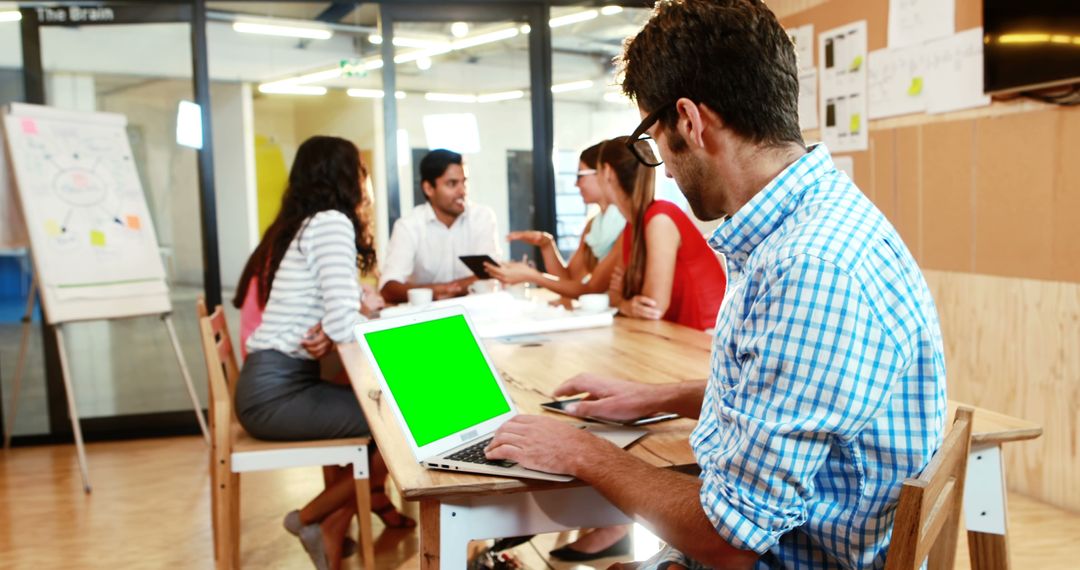 Businessman using laptop with green screen during team meeting - Free Images, Stock Photos and Pictures on Pikwizard.com