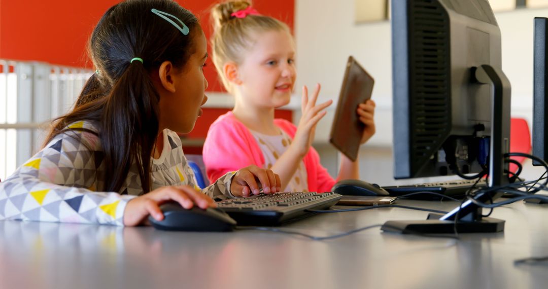 Diverse Schoolgirls Learning on Computers Together in Classroom
