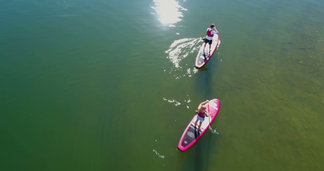 Couple Paddleboarding on Calm Lake Under the Sun - Free Images, Stock Photos and Pictures on Pikwizard.com