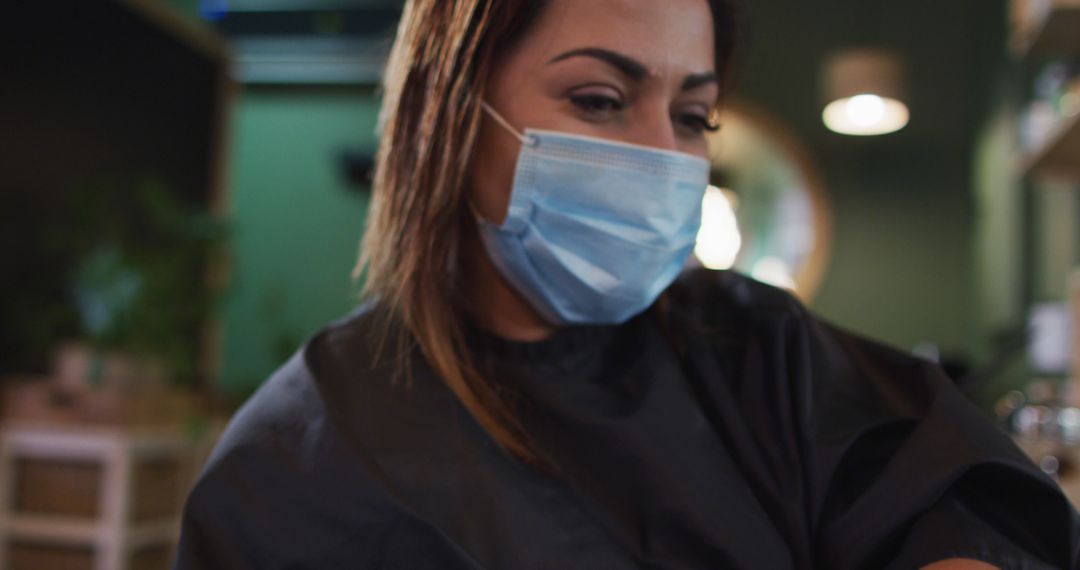 Female hairstylist in salon wearing protective face mask - Free Images, Stock Photos and Pictures on Pikwizard.com