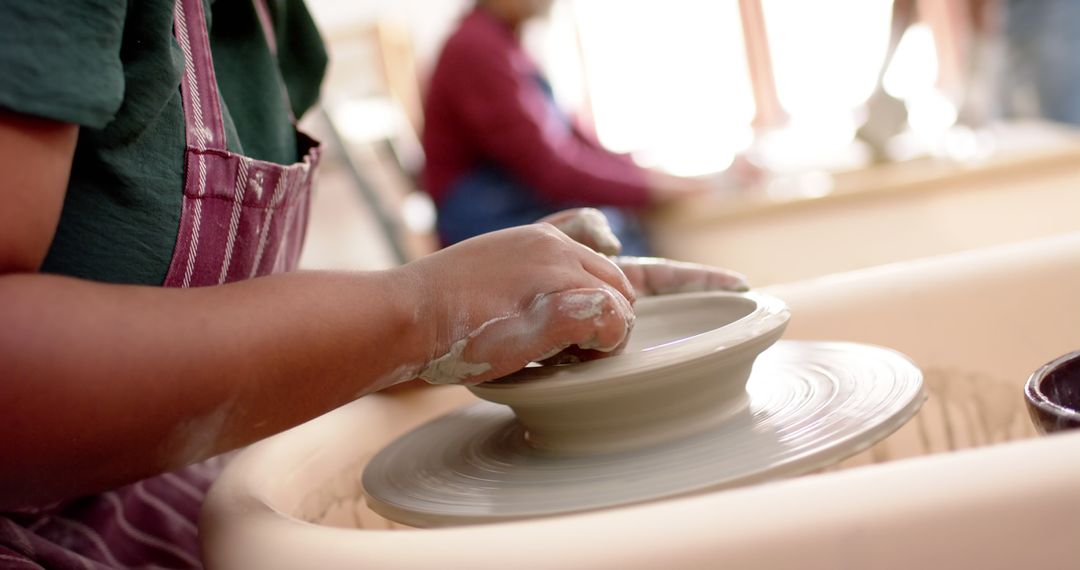 Close-up of hands shaping clay on pottery wheel in ceramics studio - Free Images, Stock Photos and Pictures on Pikwizard.com