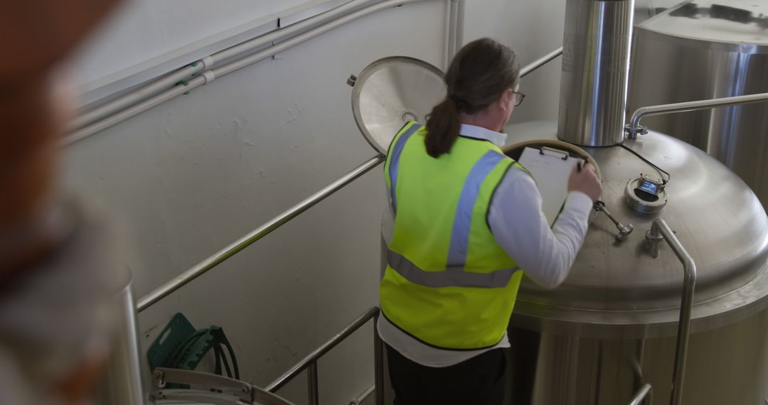 Brewery Worker Inspecting Equipment with Clipboard - Free Images, Stock Photos and Pictures on Pikwizard.com