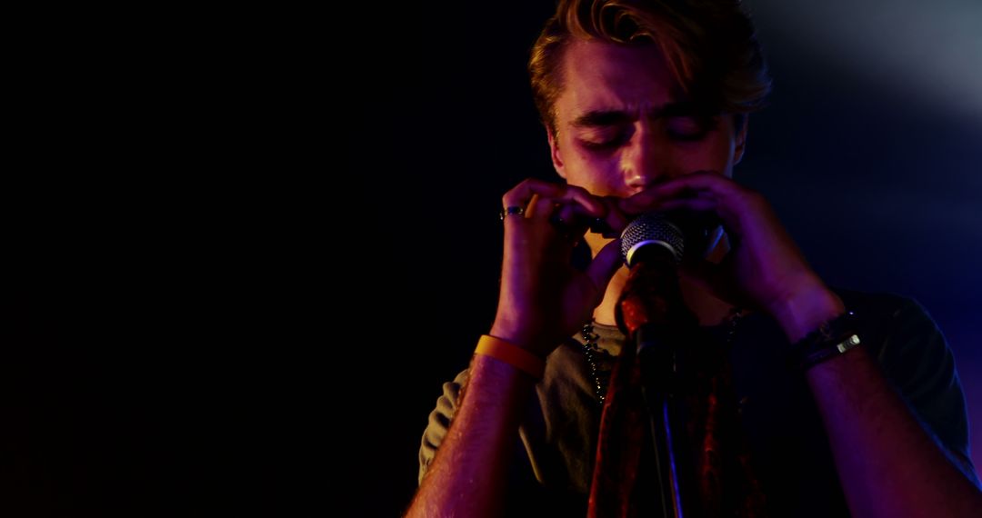 Young Musician Playing Harmonica Passionately on Stage - Free Images, Stock Photos and Pictures on Pikwizard.com