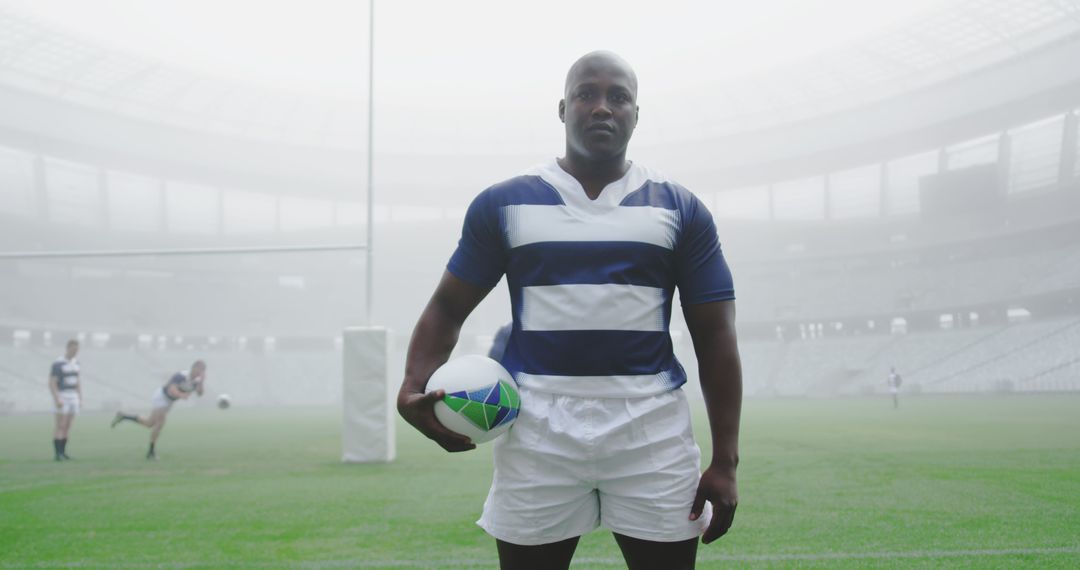 Rugby Player Holding Ball on Foggy Stadium Field in Focus - Free Images, Stock Photos and Pictures on Pikwizard.com