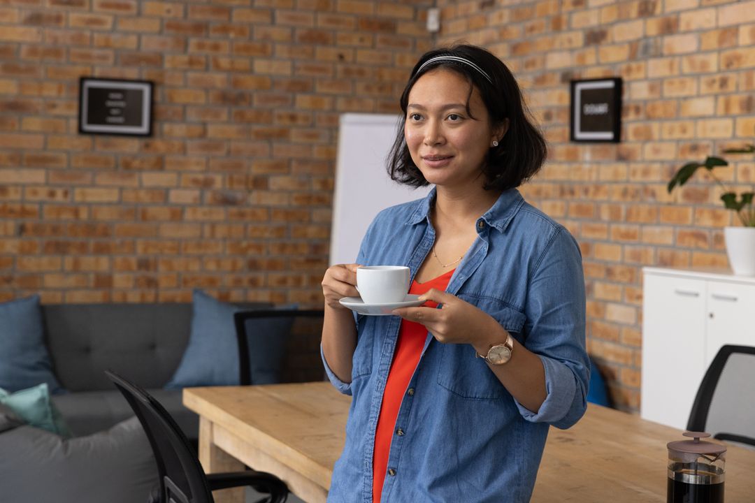 Casual Office with Asian Woman Enjoying Coffee in Collaborative Space