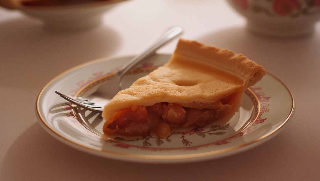 Slice of Fruit Pie on Elegant Patterned Plate with Fork