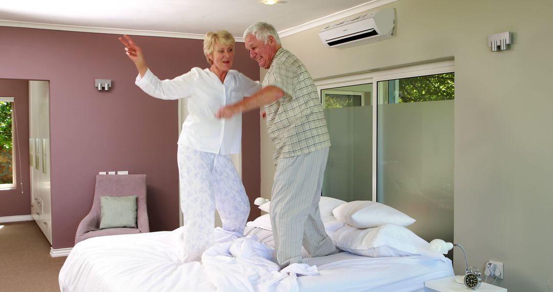 Senior Couple Jumping on Bed in Bedroom Having Fun Together - Free Images, Stock Photos and Pictures on Pikwizard.com