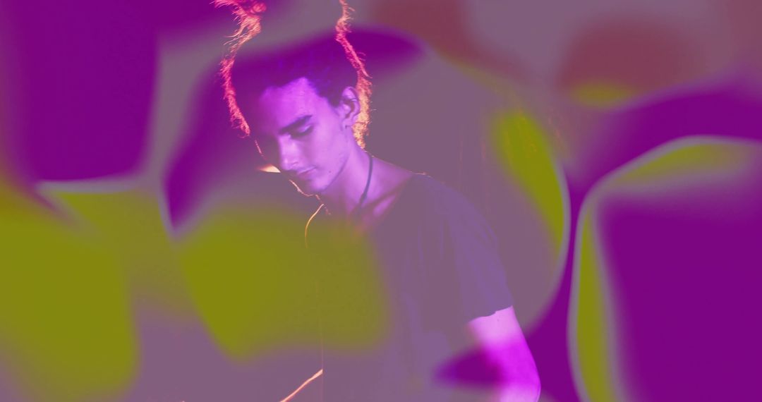 Male Performer Illuminated by Vibrant Magenta and Green Projections