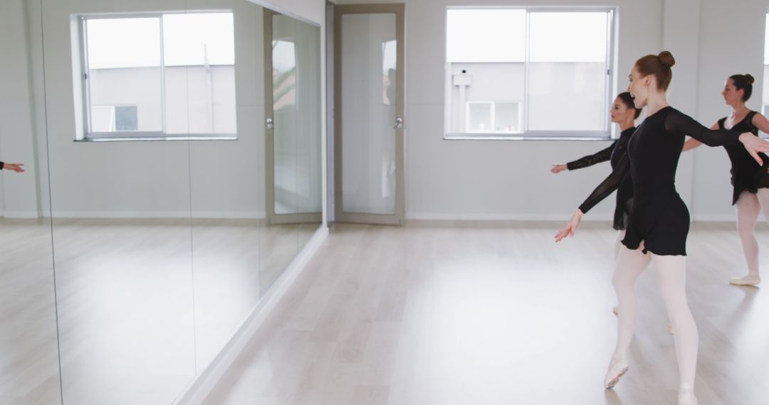 Ballet Dancers Perfecting Moves in Dance Studio with Mirror Reflexion