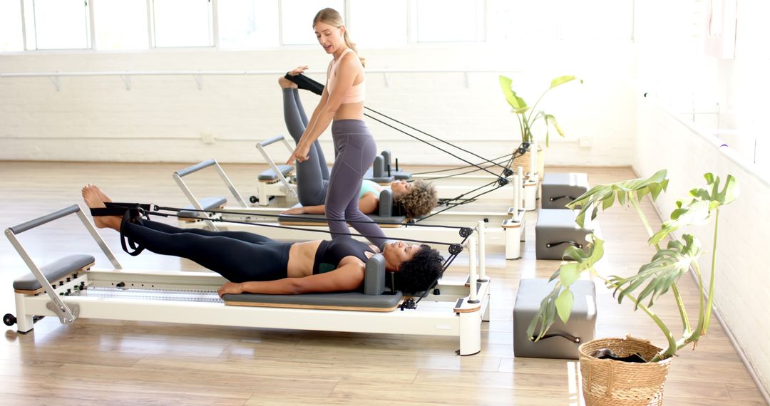 Diverse Women Engaging in Reformer Pilates Session