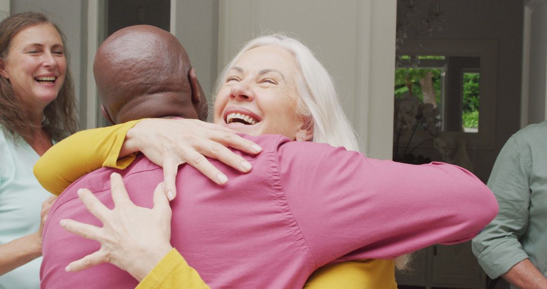 Image of happy caucasian senior woman embracing african american male friend - Free Images, Stock Photos and Pictures on Pikwizard.com